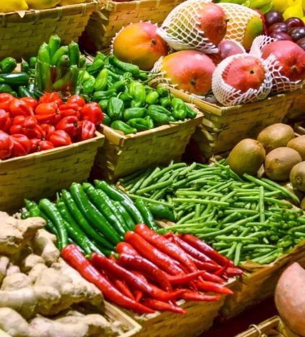 An array of vibrant fruits and vegetables, showcasing various colours and shapes, on a neutral background.